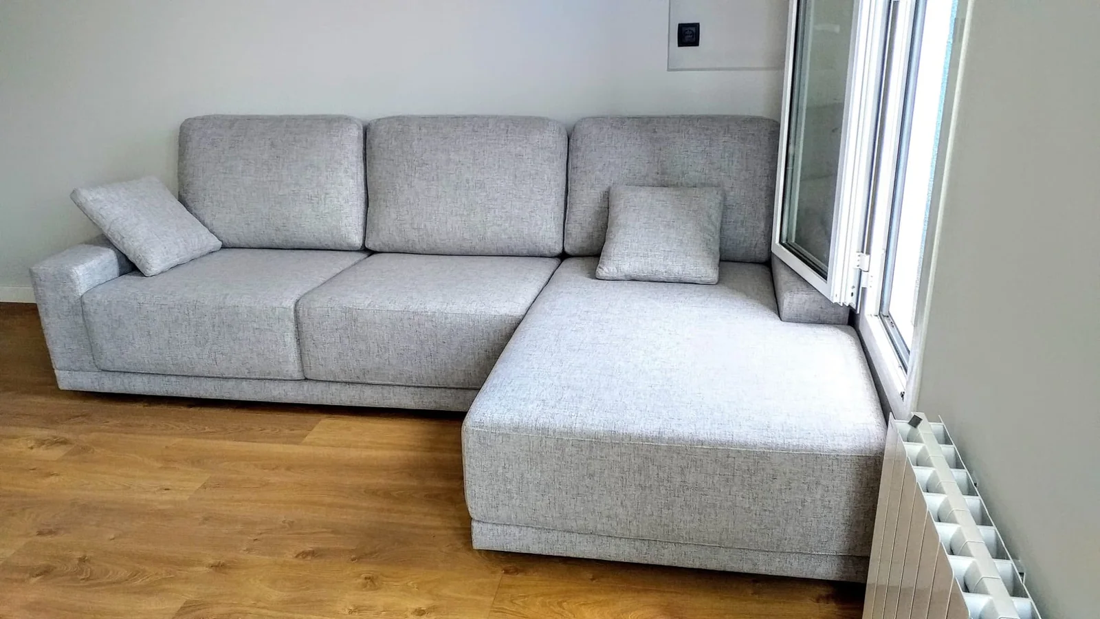 Sofá gris con chaise longue de Grupo Diper en una vivienda