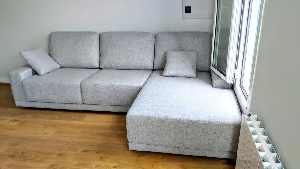 Sofá gris con chaise longue de Grupo Diper en una vivienda